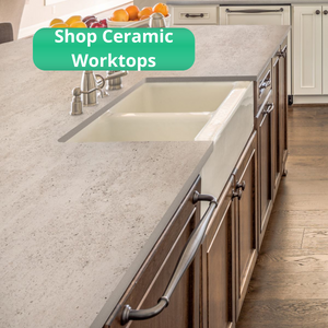 Kitchen with traditional wooden units and cream Dekton Dove ceramic kitchen worktops. Antique style taps and cupboard handles.